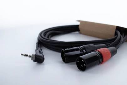 Audio kábel s 3,5 mm jack konektorom na jednej strane a dvomi XLR konektormi na druhej strane, vhodný pre audio prepojenia.