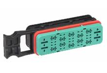 Obdĺžnikový elektrický konektor s viacerými kontaktnými bodmi, obklopený čiernym a červeným plášťom.