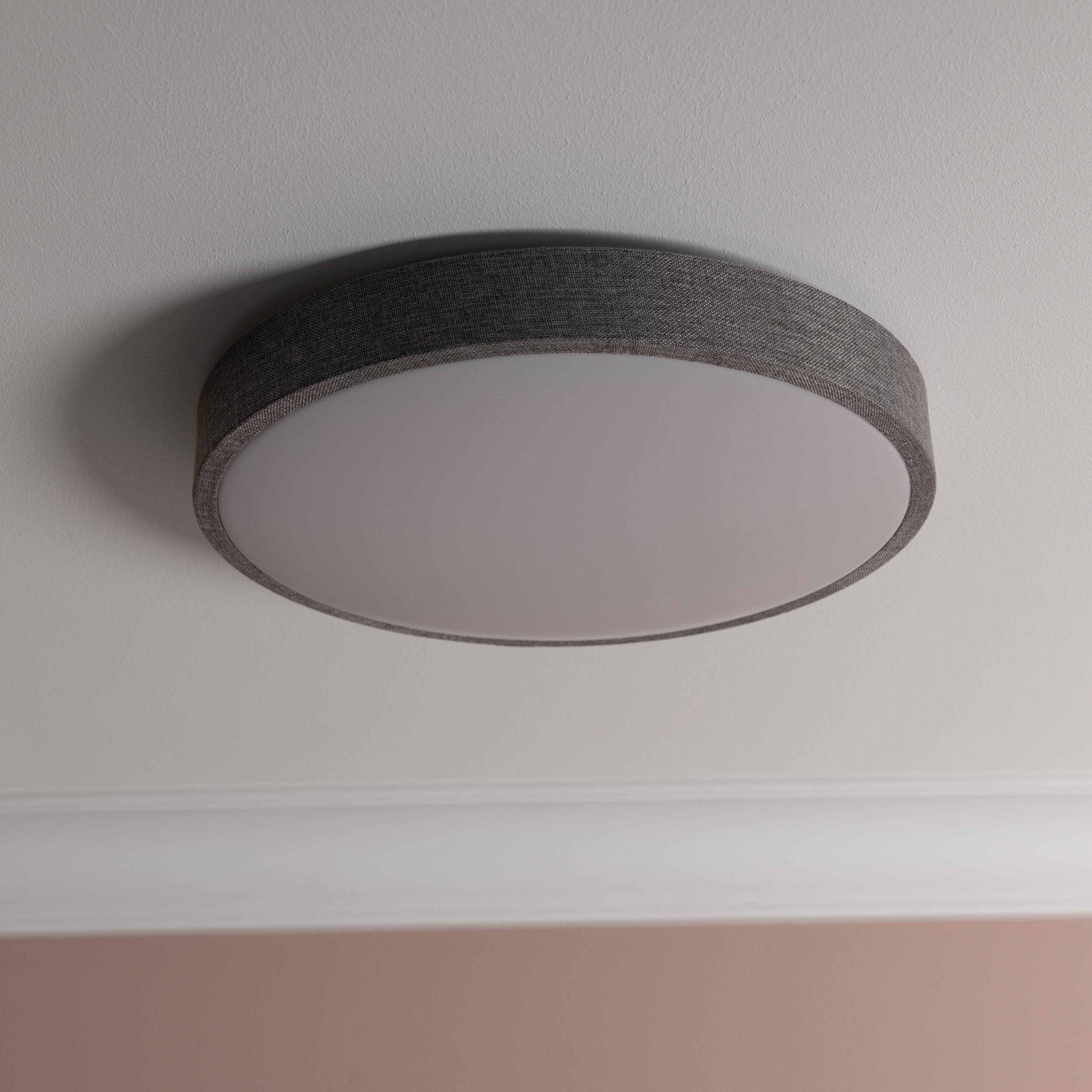 Okrúhle stropné svietidlo v modernom, minimalistickom prevedení s jasným, matným tienidlom namontované na bielom strope.