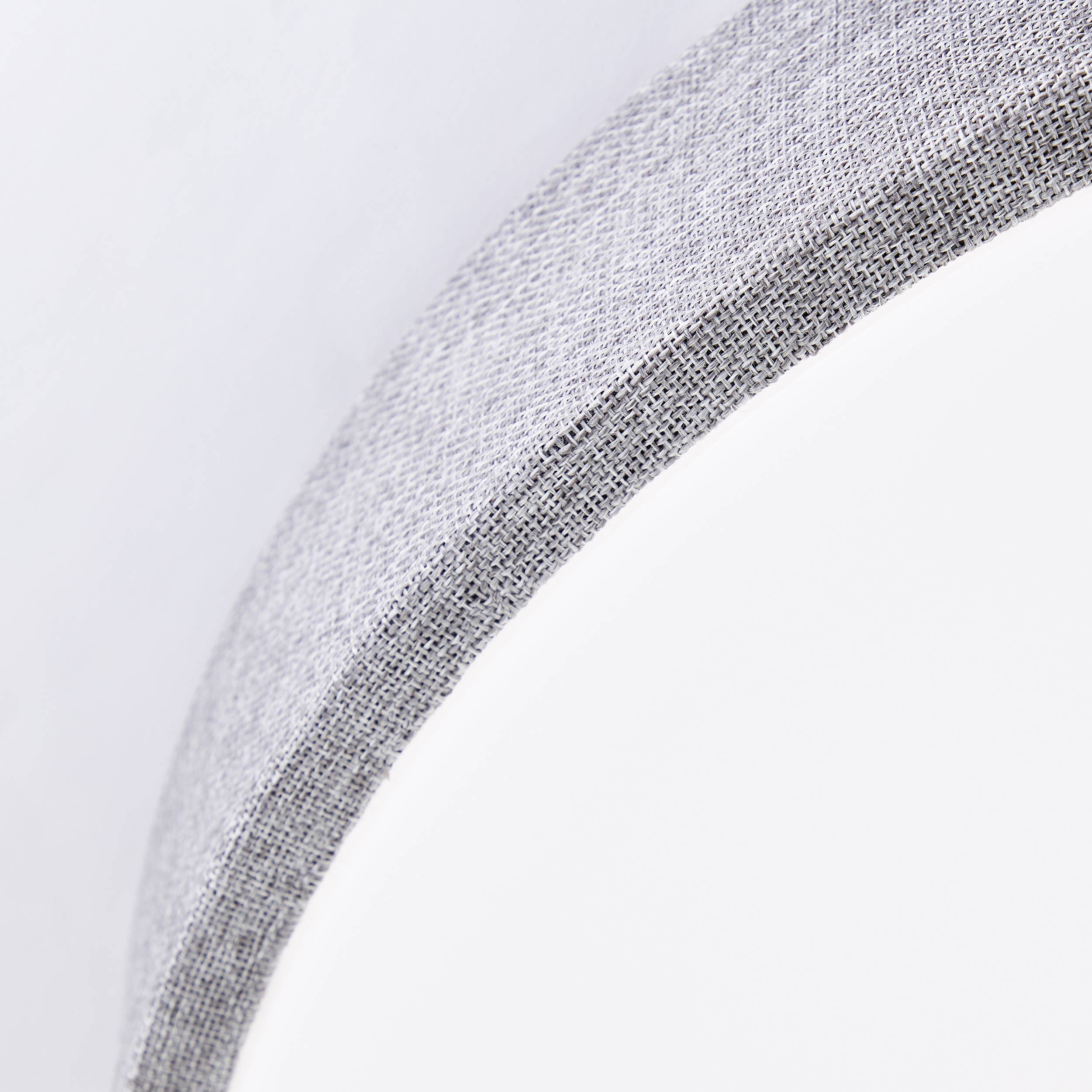 Sivý, štruktúrovaný oblúk na bielom pozadí, ktorý zobrazuje povrchovú textúru a štruktúru materiálu.