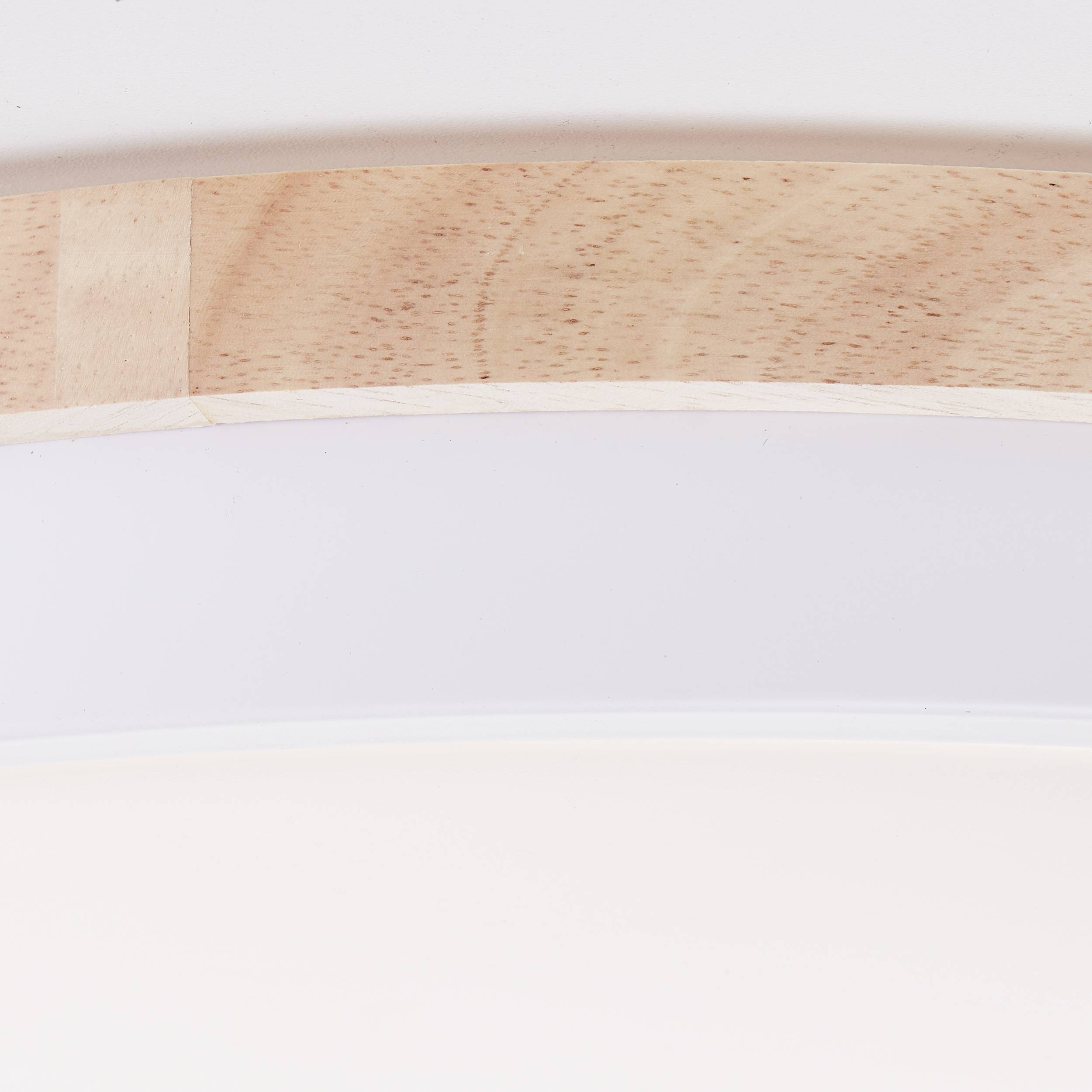 Časť okrúhleho drevného svietidla je viditeľná v čistom, svetlom prostredí.