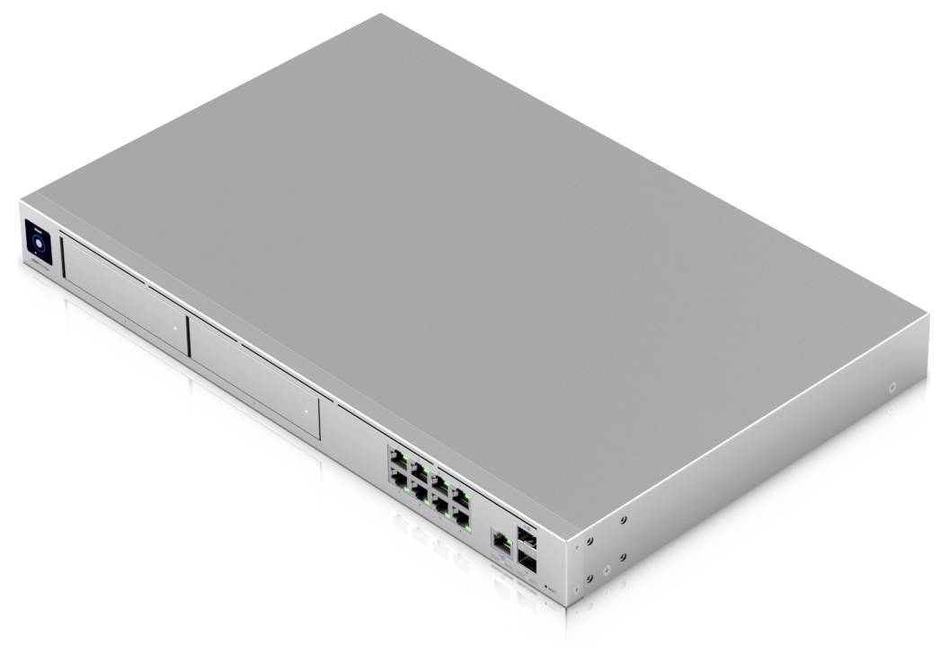 Strieborný sieťový prepínač s viacerými ethernetovými portami a dvoma prázdnymi slotmi na prednej strane, umiestnený na bielom povrchu.