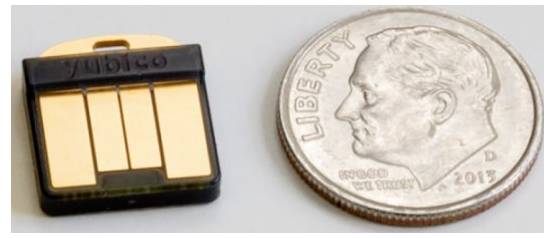 USB kľúč vedľa mince; rozdiel vo veľkosti ukazuje, aký je kľúč malý v porovnaní s mincou.