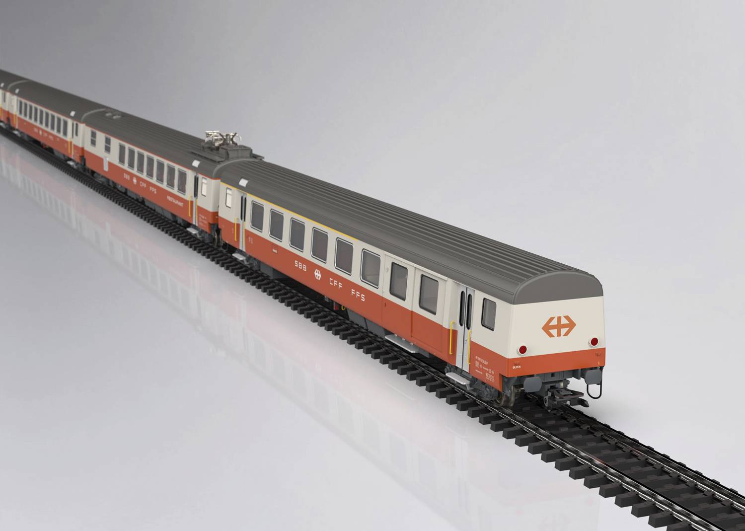 Vlakový model v červeno-bielej farbe na koľaji. Model zobrazuje niekoľko vozňov a lokomotívu s logom "SBB".