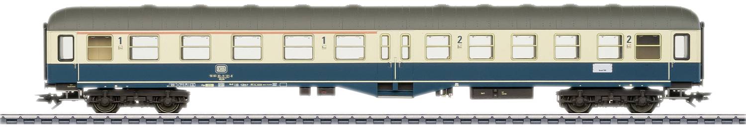 Model osobného vlakového vozňa v mierke H0 v modro-béžovej farbe, s detailne spracovanými oknami a nápismi, stojaci na koľajniciach.