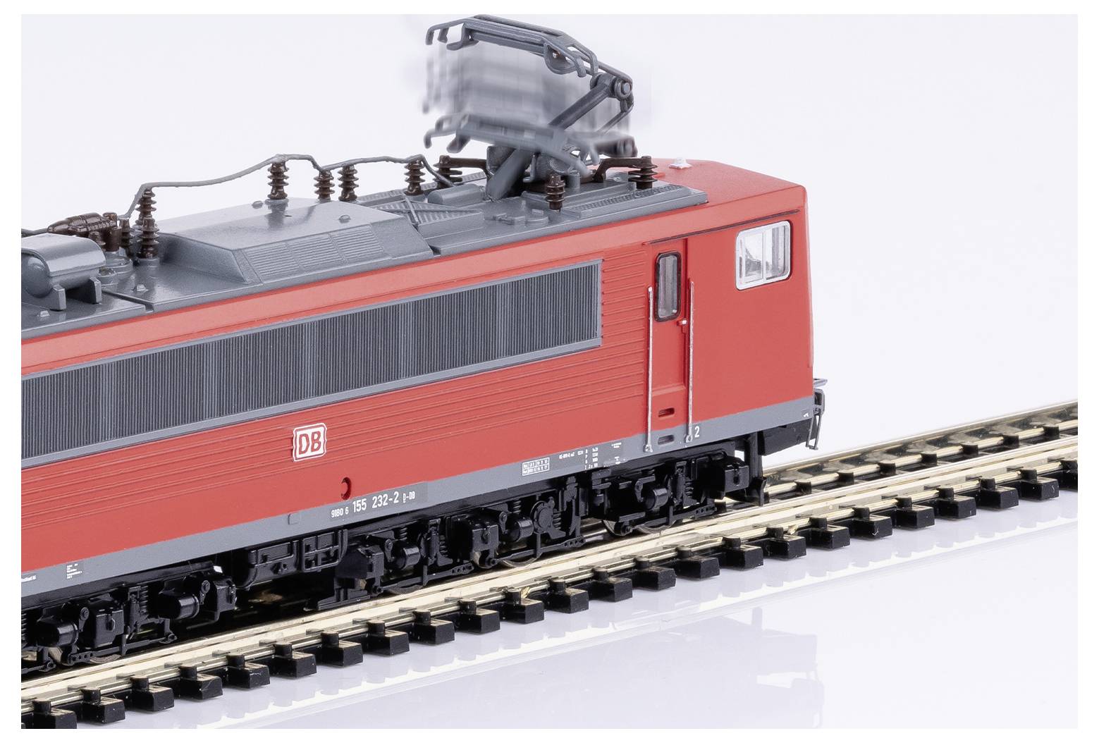 Červený model elektrickej lokomotívy Deutsche Bahn na železničnom úseku, pohľad zboku zozadu.