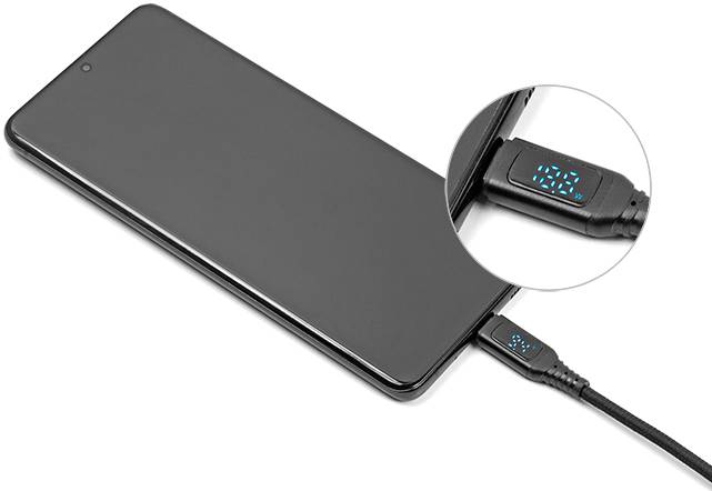 Smartfón sa nabíja pomocou kábla, ktorý zobrazuje rýchlosť nabíjania na malom displeji.