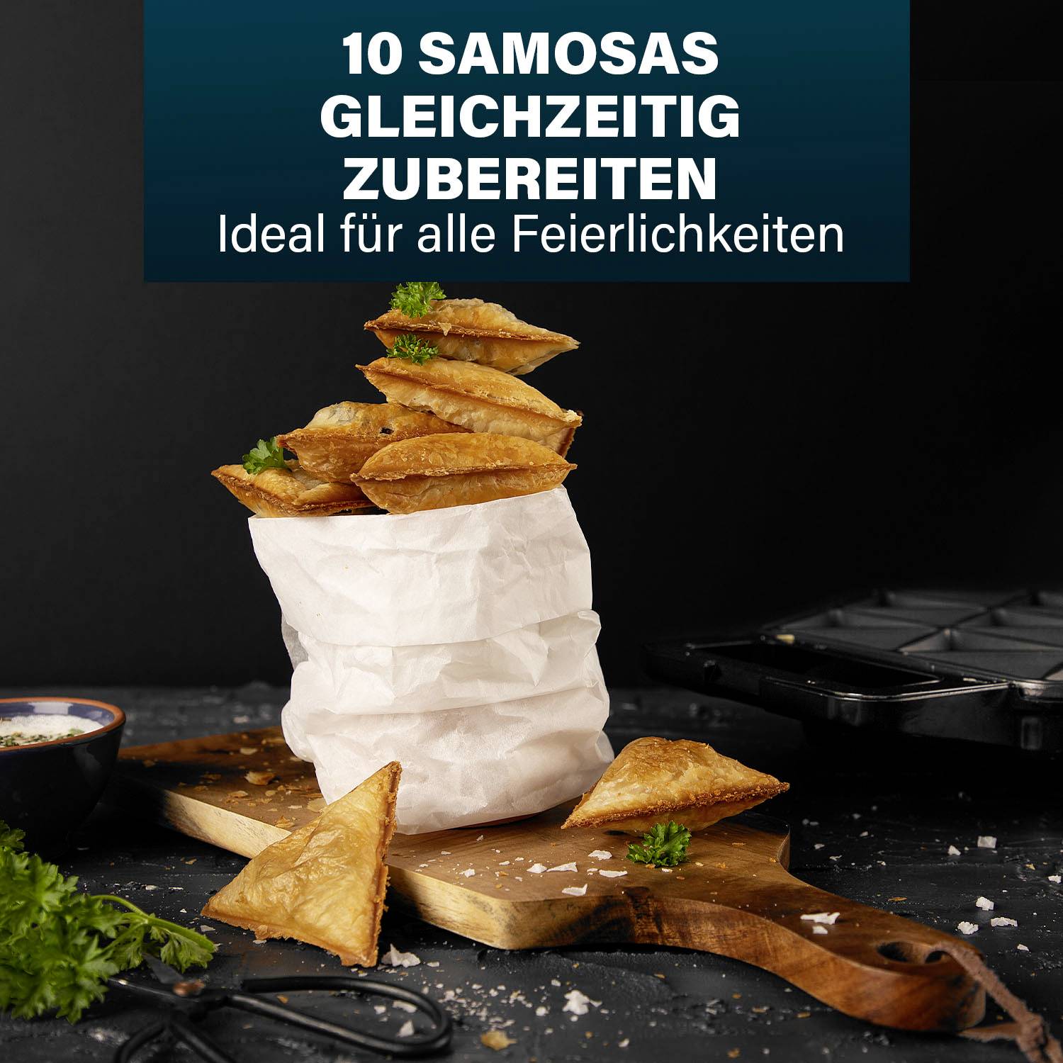 10 samós pripravených naraz. Ideálne pre všetky oslavy. Samósy na drevenej doske, ozdobené čerstvými bylinkami.