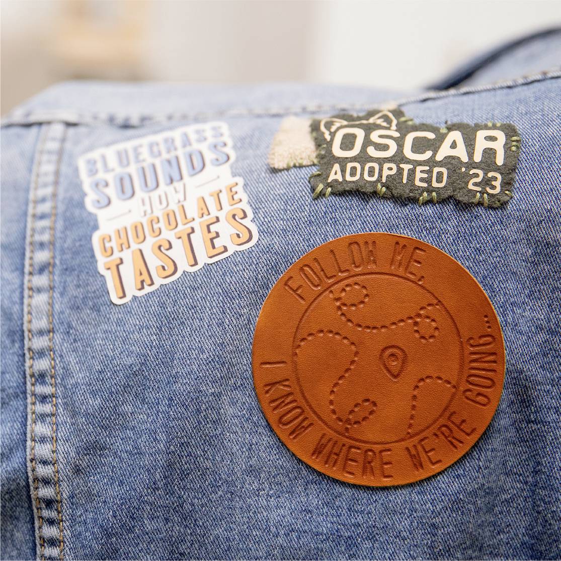 Bunda s dvoma nášivkami: Jedna kožená s nápisom 'Nasleduj ma, viem, kam ideme' a druhá s nápisom 'Oscar Adopted '23'.