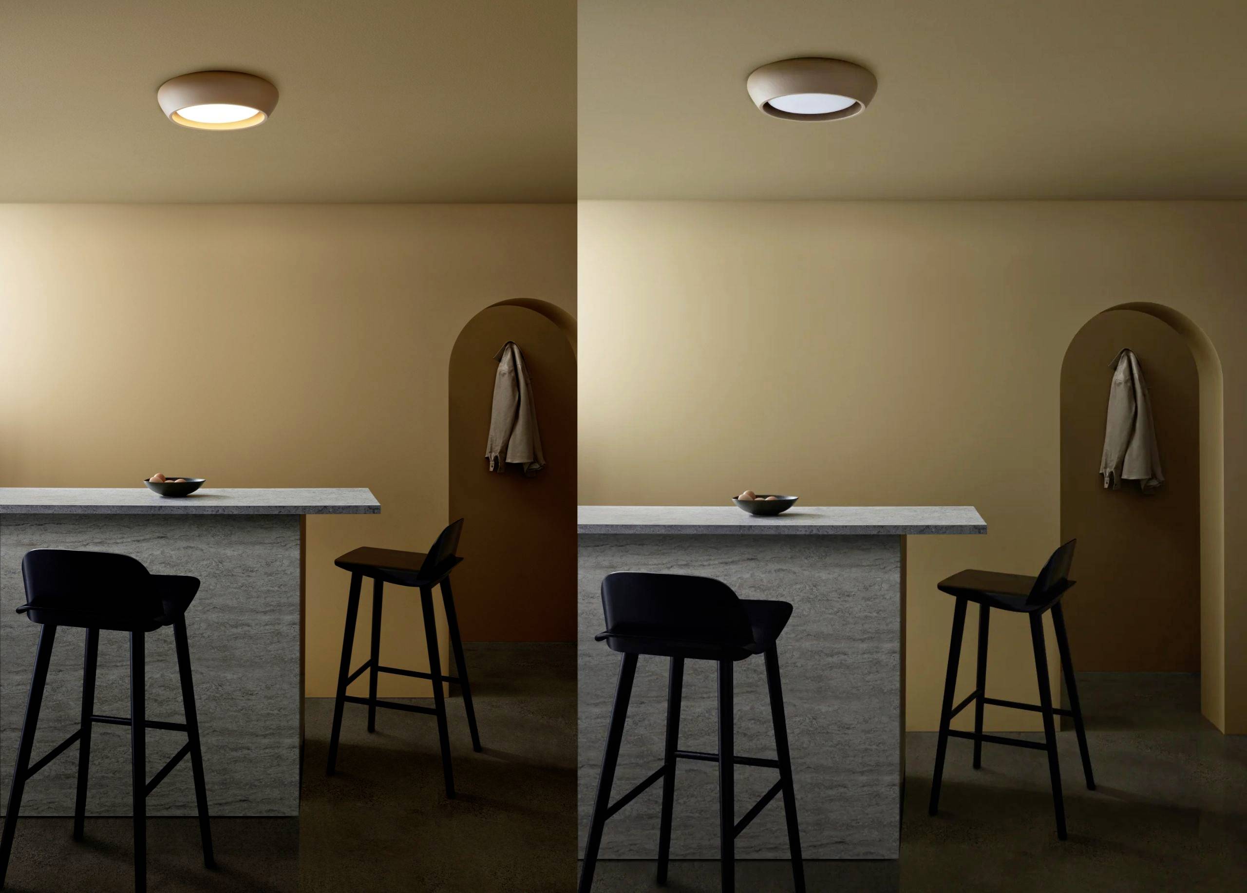 Dva obrazy miestnosti so stolom na pitie a stoličkami. Vľavo so zapnutým teplým svetlom, vpravo so zhasnutým svetlom. Bunda visí na vešiaku na stene.