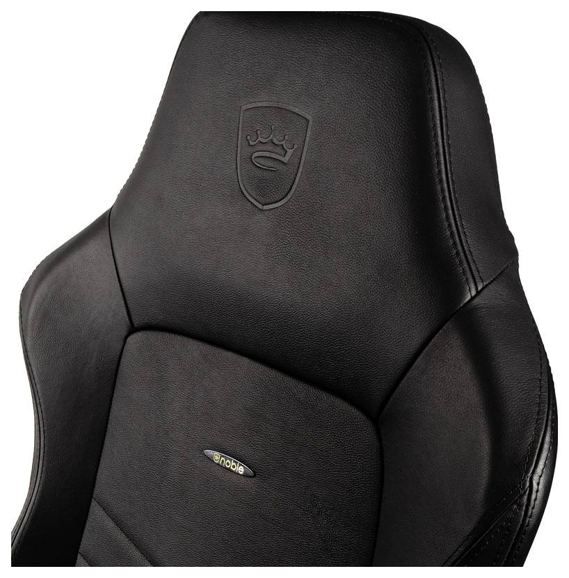 Čierny herný stolček s vyšívaným logom na opierke hlavy. Elegantný dizajn, ergonomicky tvarovaný pre dlhodobý komfort.