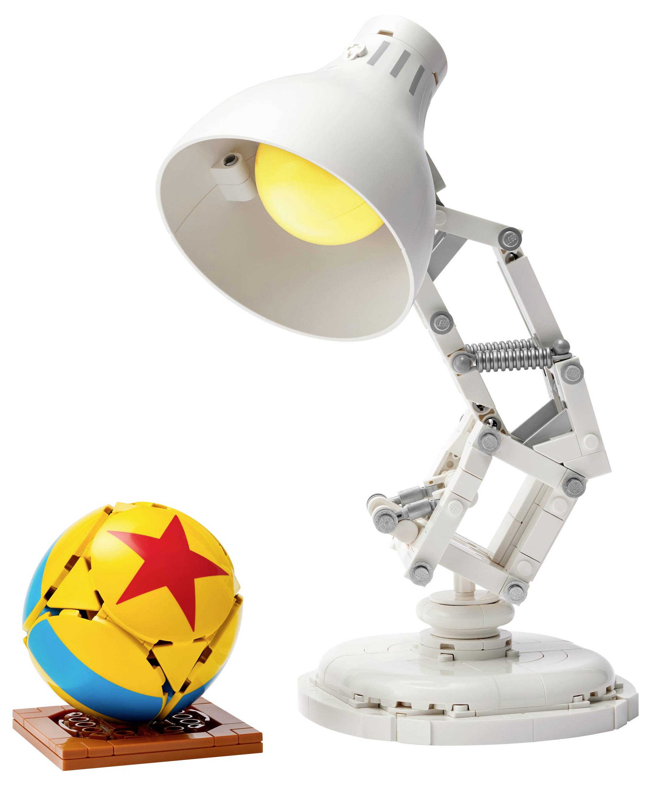 Biela stolová lampa z LEGO vedľa žlto-modrej lopty s červenou hviezdou z LEGO.