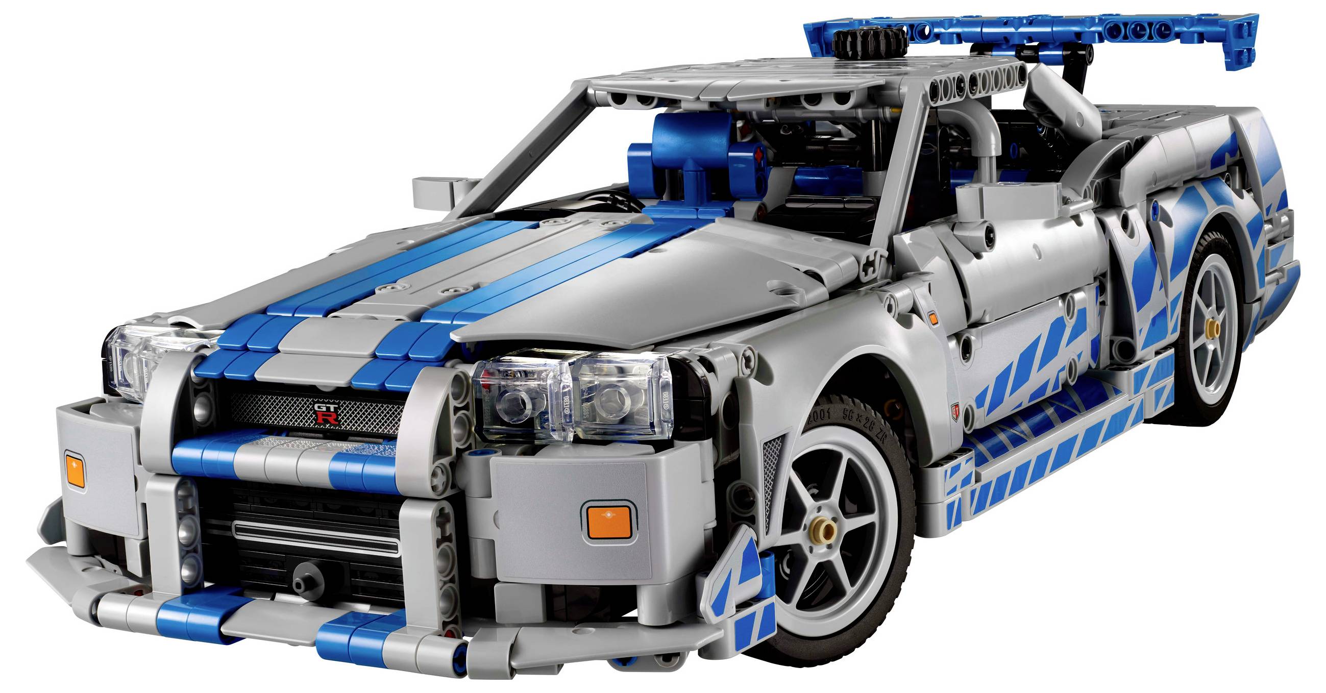 LEGO model strieborného športového auta s modrými pruhmi. Detailná replika s viditeľným motorom a pretekárskym spoilerom.
