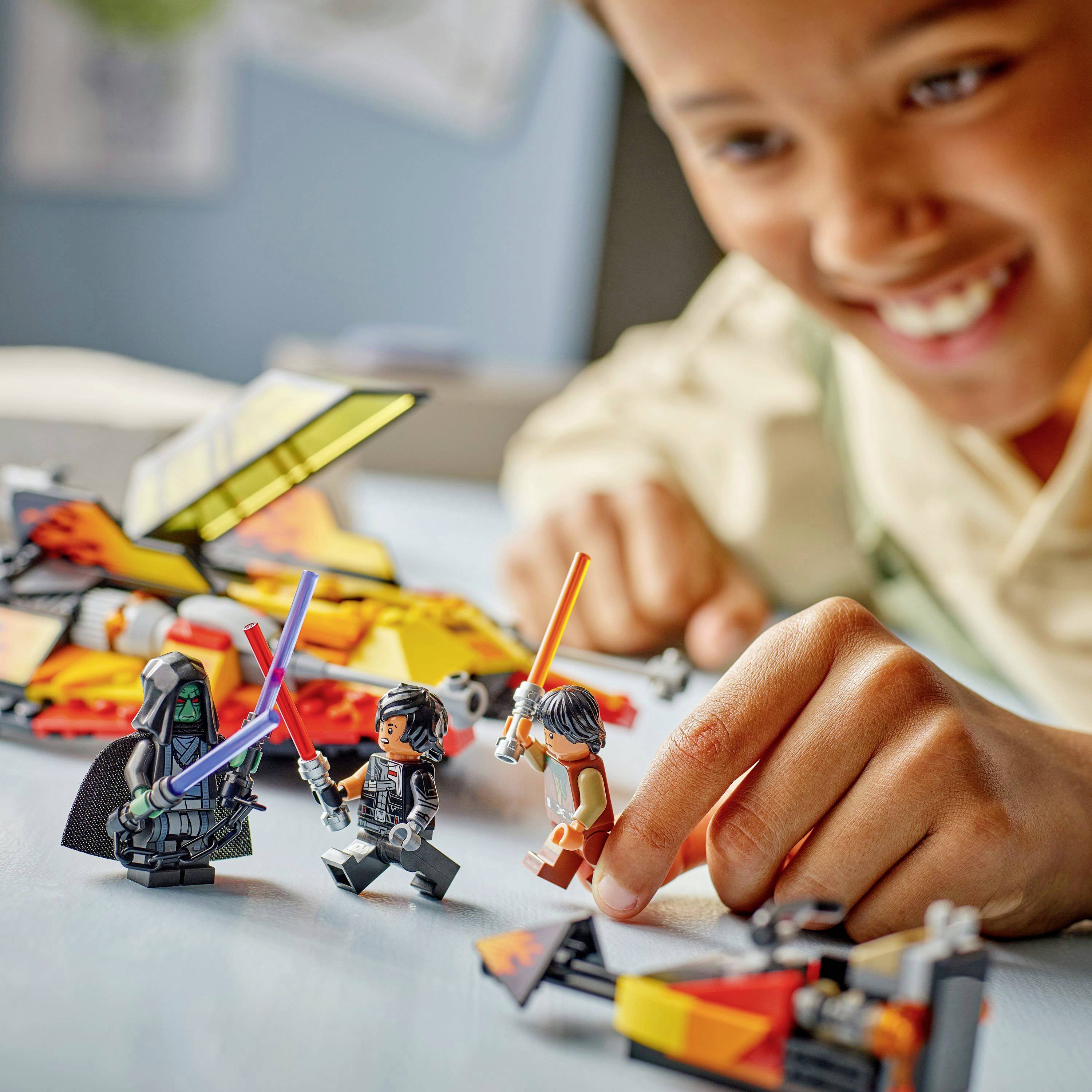 Dieťa sa usmieva, keď sa hrá s hračkárskymi figúrkami. Figúrky pripomínajú postavy z vesmírnej fantasy, každá drží farebný meč.