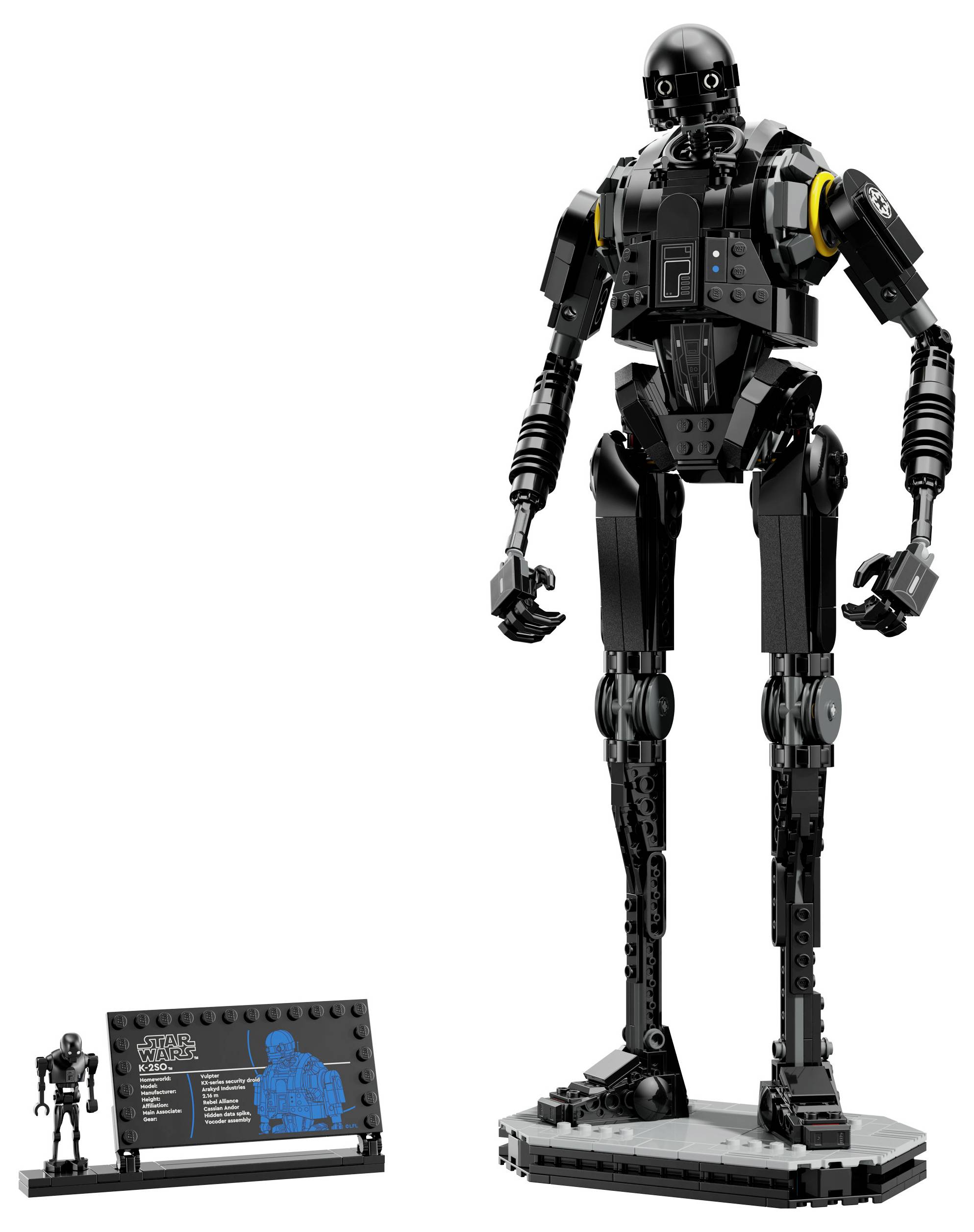 Vysoká, čierna robotická postava vyrobená z konštrukčných blokov stojí na podstavci. Vedľa nej je menšia verzia a informačná tabuľka.