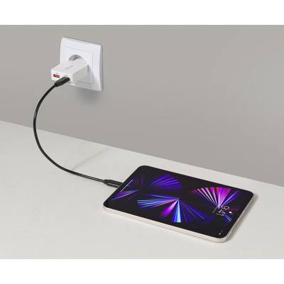 Tablet nabíjajúci sa na pracovnej doske, pripojený k elektrickej zásuvke prostredníctvom USB-C kábla a nabíjačky. Tablet zobrazuje živý abstraktný dizajn.