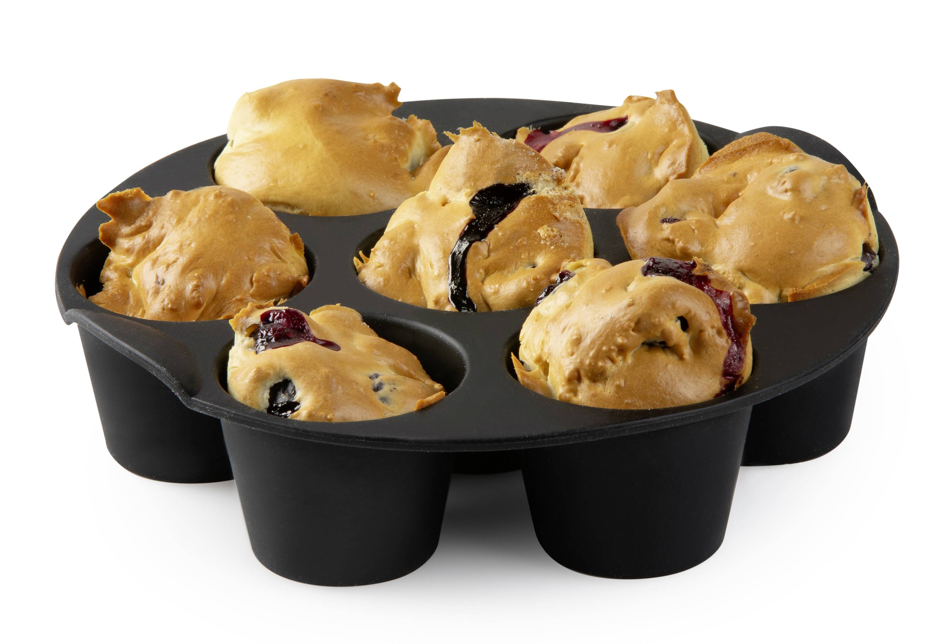 Muffiny v čiernej pečiacej forme, rovnomerne upečené, so zlatohnedým povrchom.