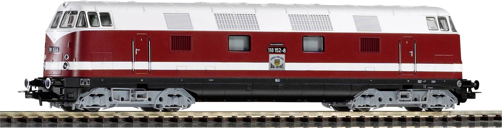 Červený a biely vlak na koľajniciach, pohľad zboku. Model historickej lokomotivy, osvetlené okná, čierne podvozok.