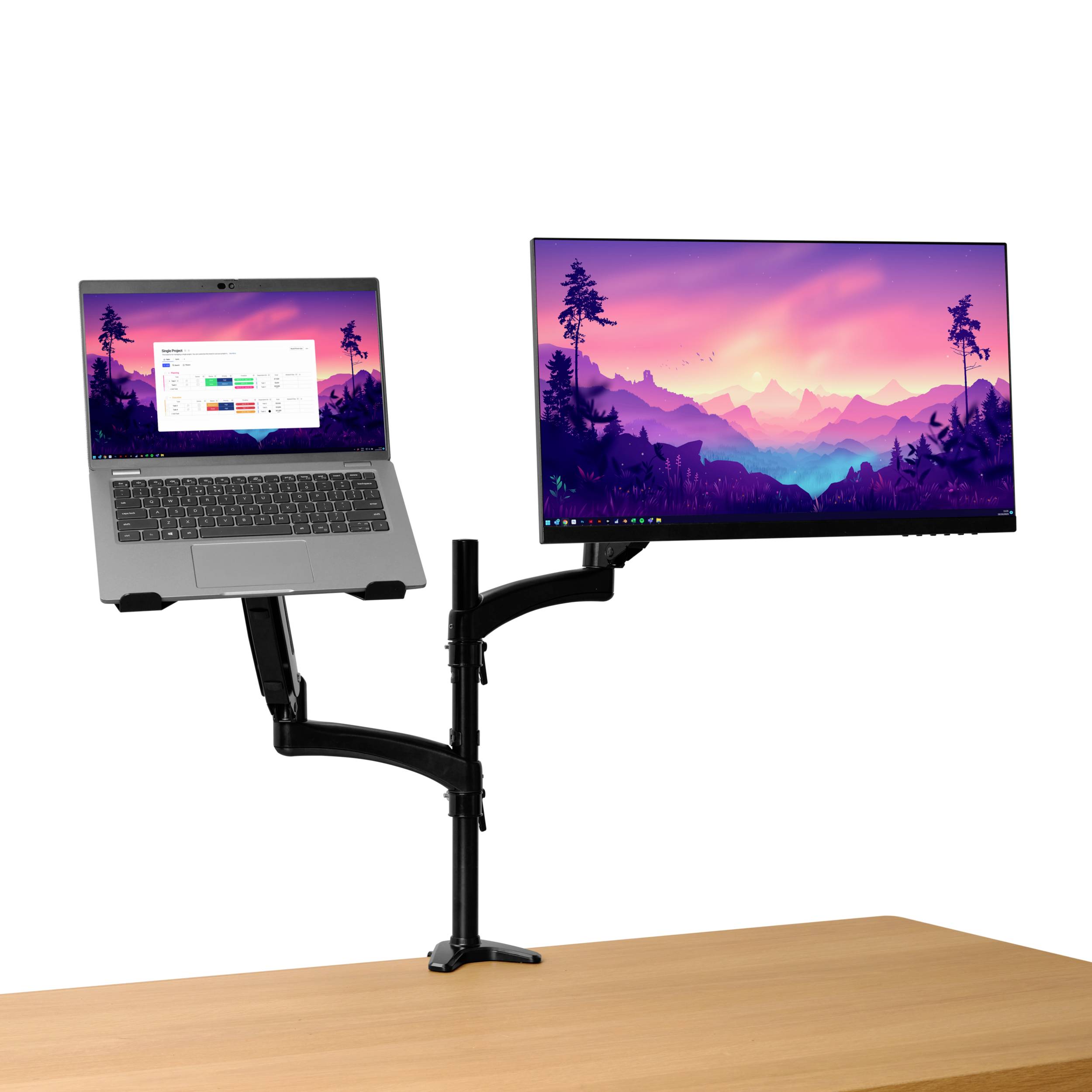 Zostava s dvoma obrazovkami na stole: vedľa seba namontovaný notebook a monitor. Monitor zobrazuje krajinu pri západe slnka.