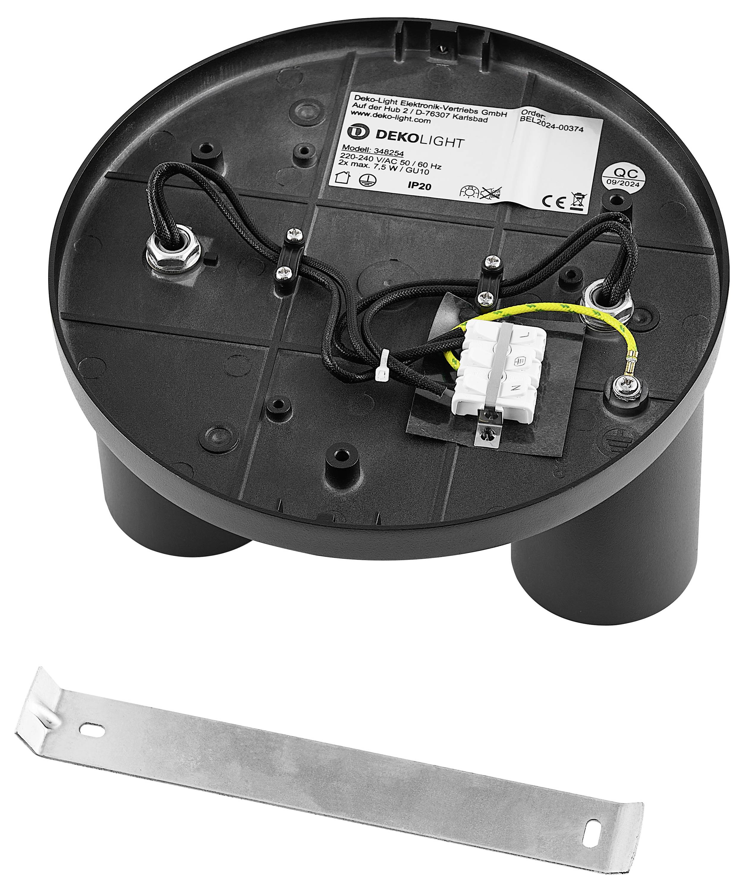 Guľatý spodok elektrickej inštalácie s káblami a svorkovnicami. Samostatná kovová svorka leží vedľa.