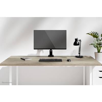 Minimalistický písací stôl s monitorom, klávesnicou, myšou, lampou, poznámkovým blokom a rastlinou.