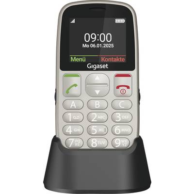 Strieborný mobilný telefón s veľkou klávesnicou v držiaku. Displej zobrazuje 'Po 06.01.2025, 09:00'. Možnosť pre 'Menu' a 'Kontakty'.