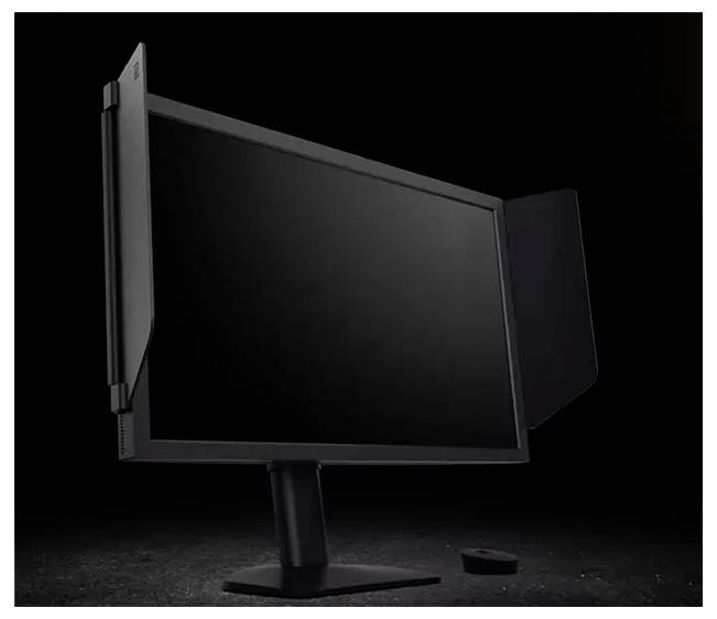 Čierny počítačový monitor so súkromnými filtrami na bokoch je zobrazený na tmavom pozadí. Malé diaľkové ovládanie leží vedľa neho.