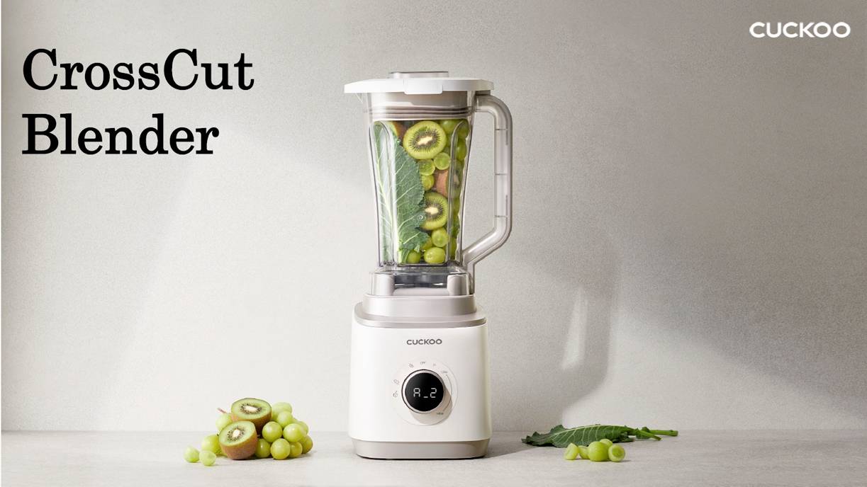 Mixér označený ako 'CrossCut Blender' obsahujúci listovú zeleninu, kivi a hrozno. Značka 'Cuckoo' je viditeľná v hornej pravej časti.