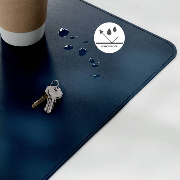 Šálka na kávu a kľúče na vodotesnom modrom povrchu s kvapkami vody, čo naznačuje, že materiál odoláva absorpcii kvapalín.