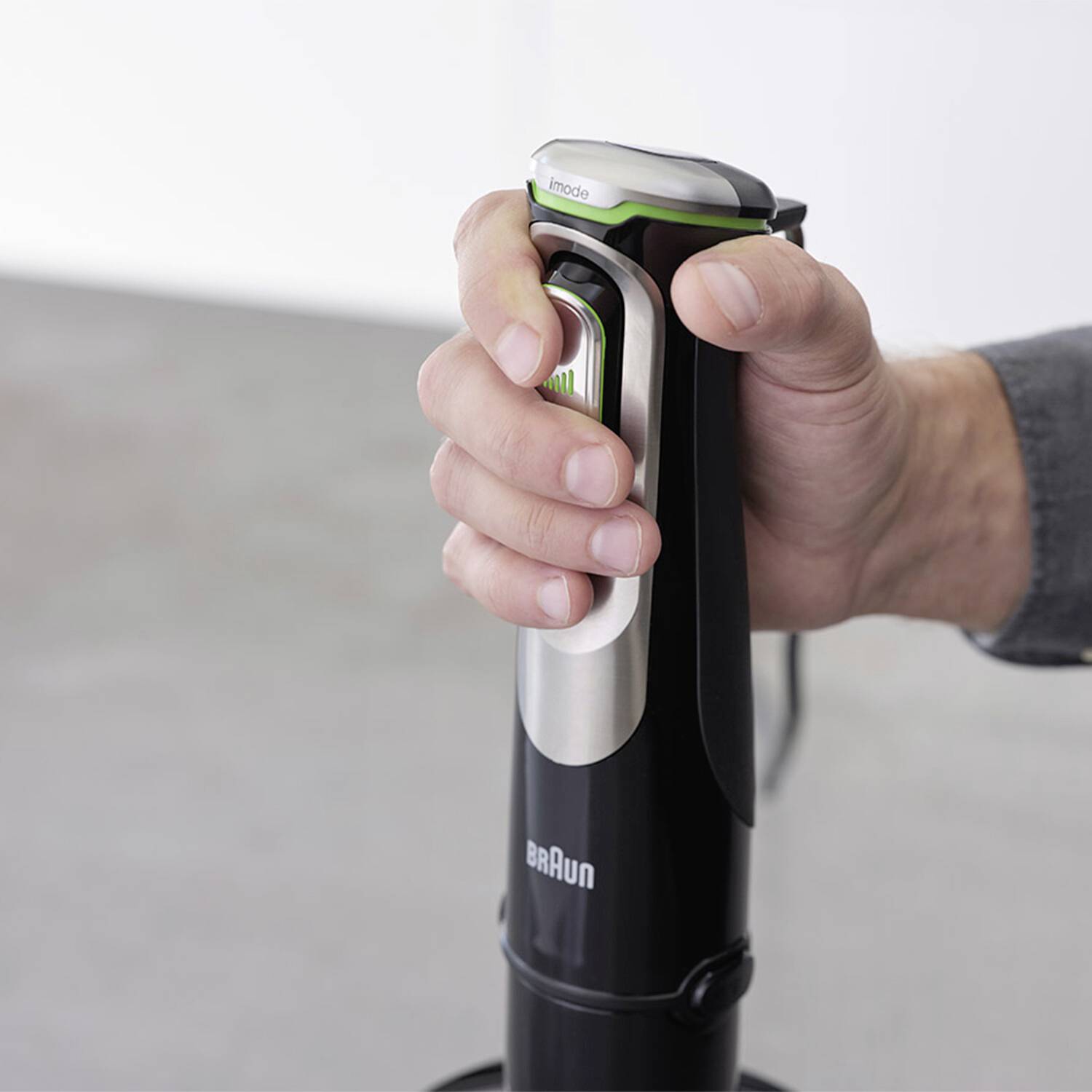 Ruka človeka držiaca ručný mixér Braun, ktorá ilustruje ľahké používanie a ergonomický dizajn v modernom kuchynskom prostredí.