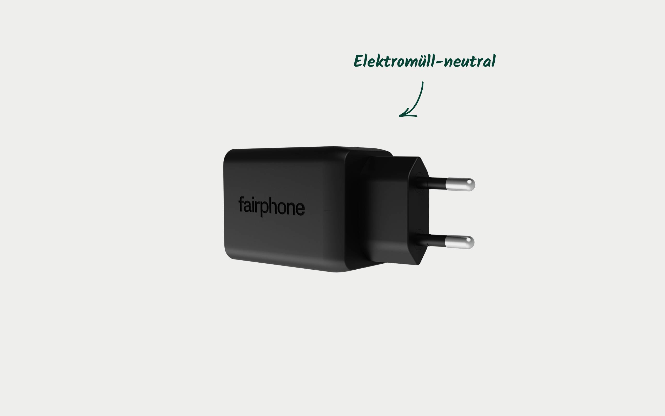 Čierna nabíjačka od Fairphone s európskou zástrčkou. Text: 'Neutrálny elektronický odpad', čo poukazuje na environmentálnu šetrnosť.