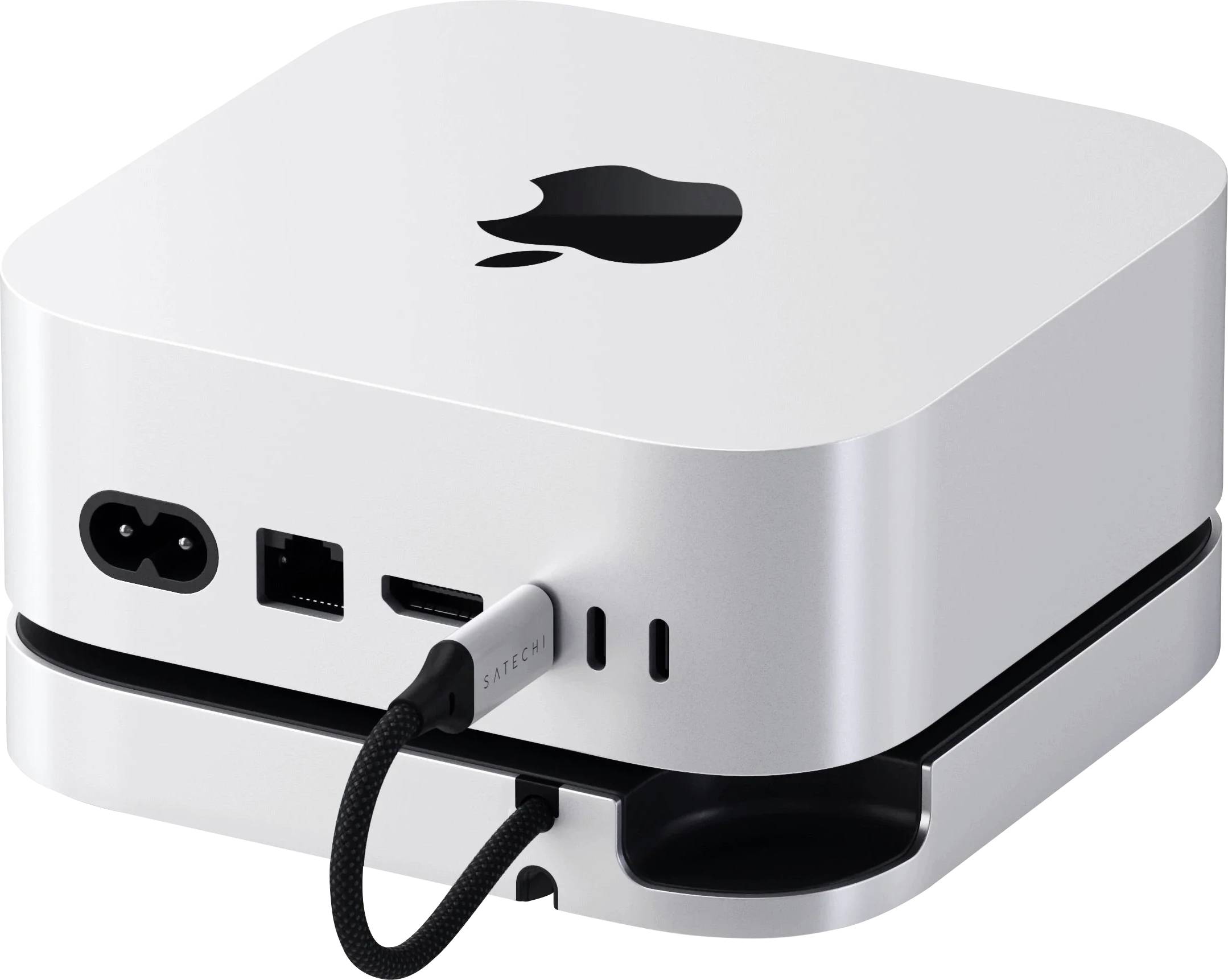 Malé, strieborné zariadenie s logom Apple, s portami pre napájací, USB a HDMI kábel na zadnej strane. Kábel je zapojený.