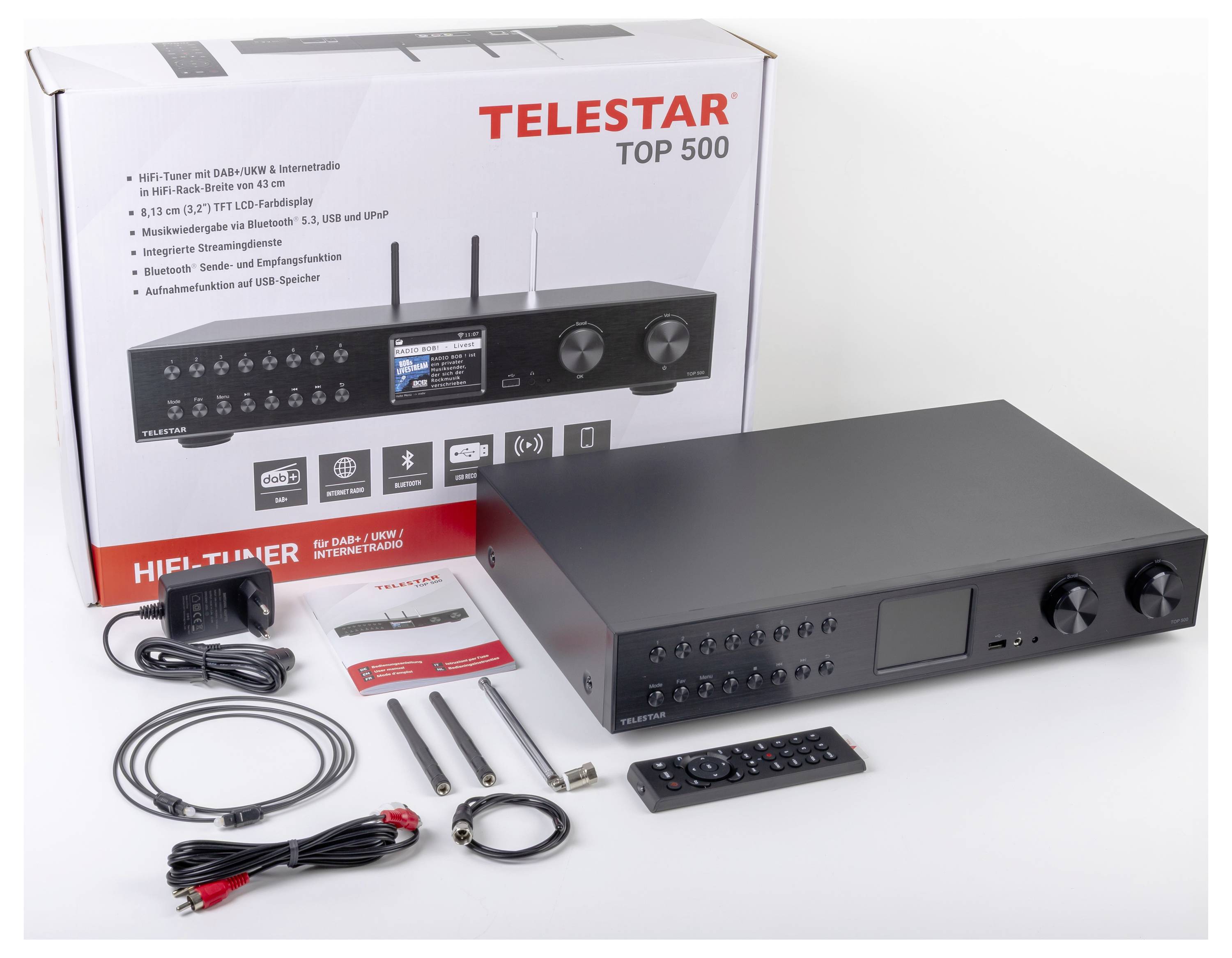 Digitálny prijímač Telestar Top 500 s diaľkovým ovládačom, káblami a anténami je vystavený vedľa krabice, ktorá zobrazuje funkcie vo viacerých jazykoch.