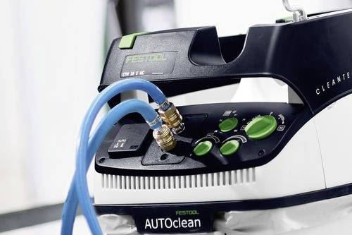 Detailný záber na zariadenie Festool AUTOClean, ktoré má pripojené dva modré hadice ku konektorom, s rôznymi ovládacími tlačidlami a rukoväťou na prenášanie.