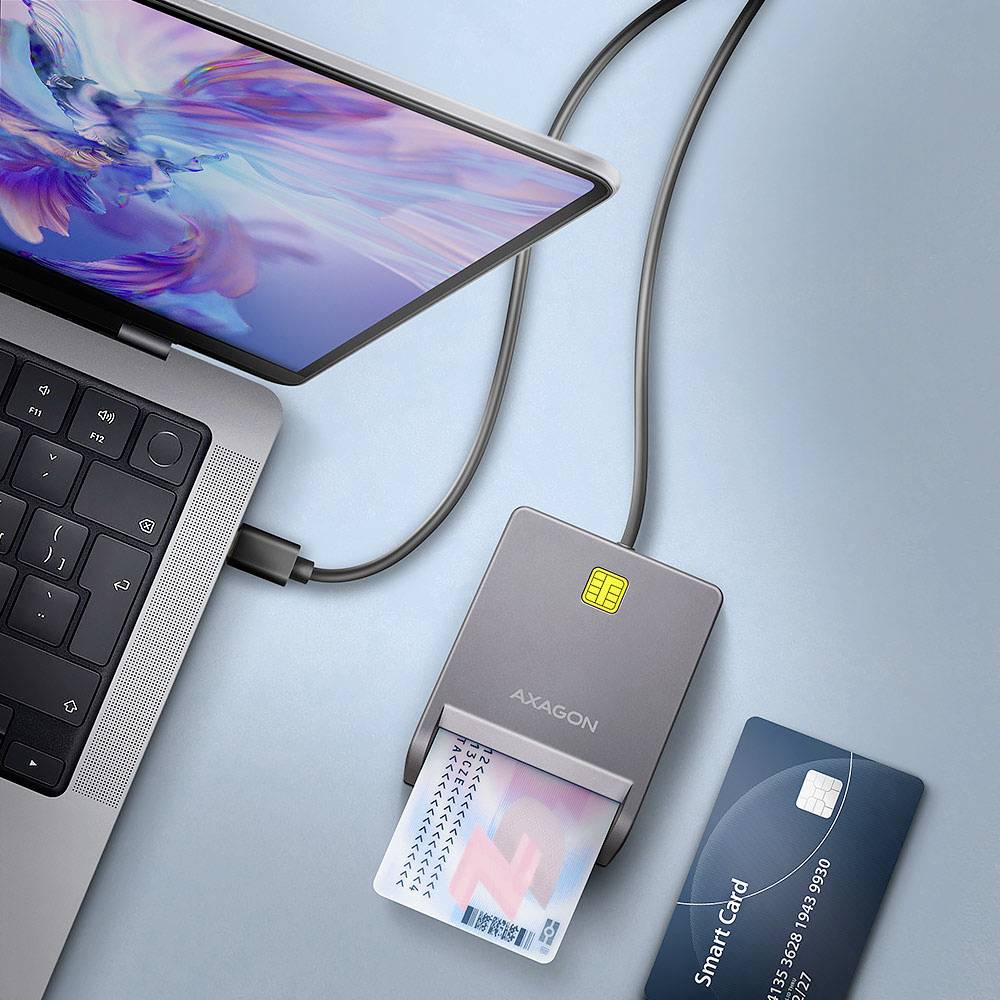 Laptop sa pripája ku čítačke kariet, kde je vložená karta, vedľa ktorej sa nachádza inteligentná karta.