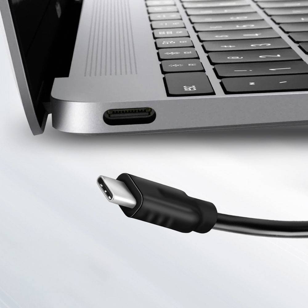 Kábel USB-C sa chystá pripojiť do portu USB-C na striebornom laptope, pričom zvýrazňuje kompatibilitu a konektivitu.