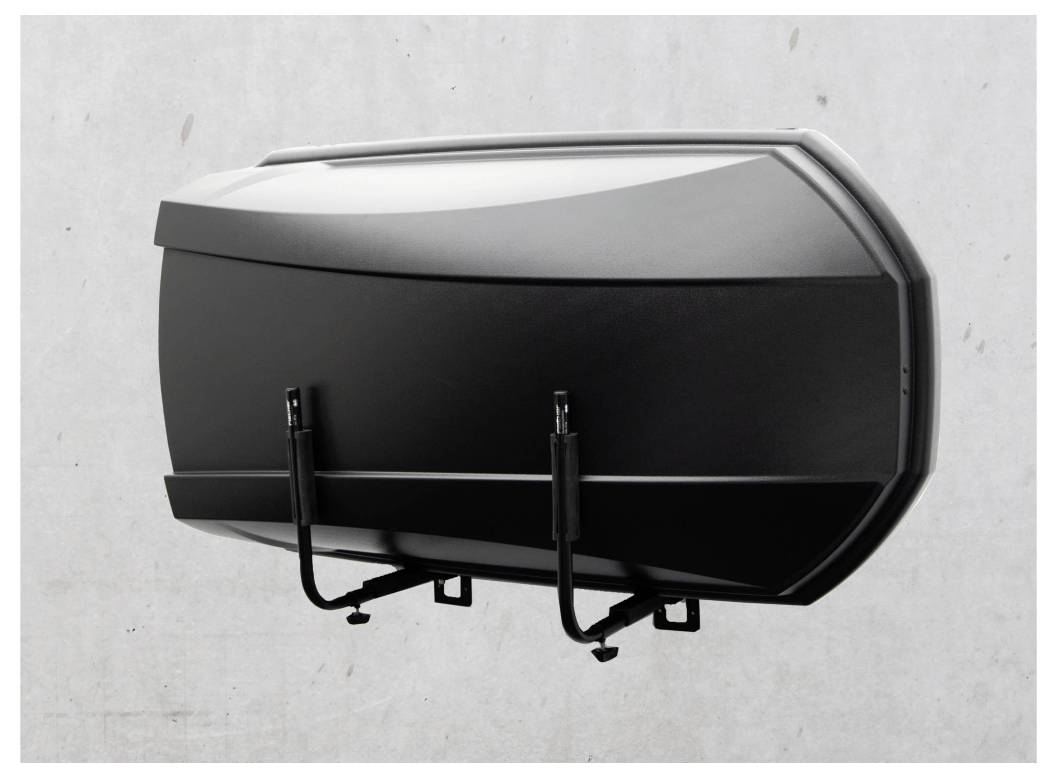 Čierny a strieborný hard-shell nákladný box alebo úložný box pripevnený na stene na svetlosivej stene