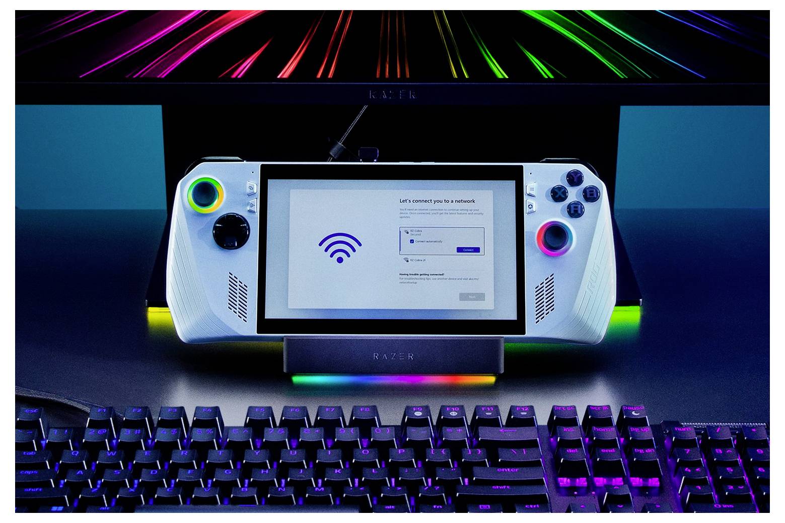 Herná konzola s obrazovkou zobrazuje nastavenie Wi-Fi pripojenia. Farebné LED svetlá lemujú zariadenie a pod ním je viditeľná klávesnica.