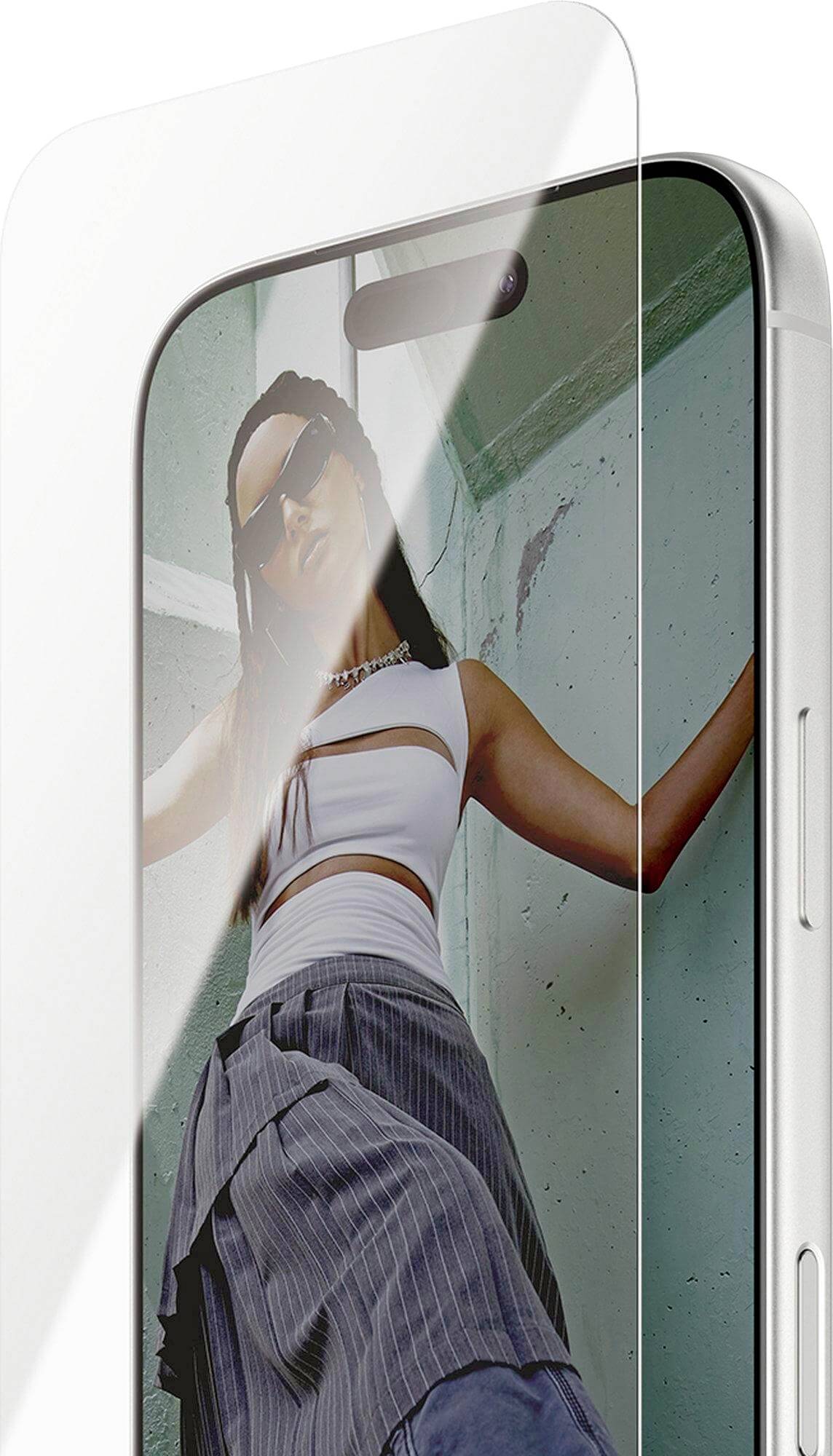 Smartphone s priehľadnou ochrannou fóliou zobrazuje ženu oblečenú v bielom tope a sivej sukni. Obrázok demonštruje transparentnosť ochrannej fólie.