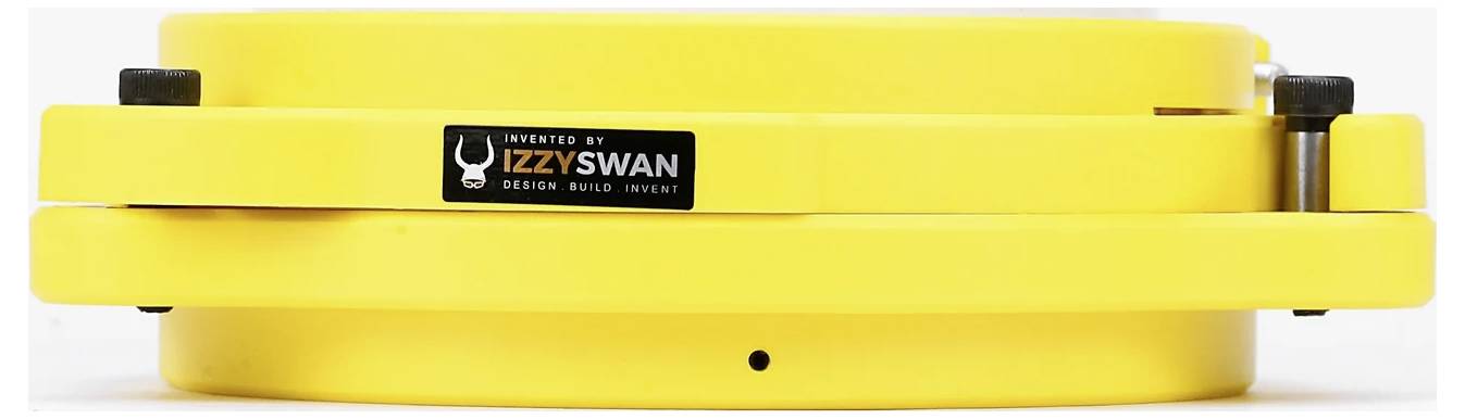 Žlté, stohovateľné zariadenie s nálepkou "Vynájdené Izzy Swan Design Build Invent". Pravdepodobne nástroj alebo súčasť vybavenia.