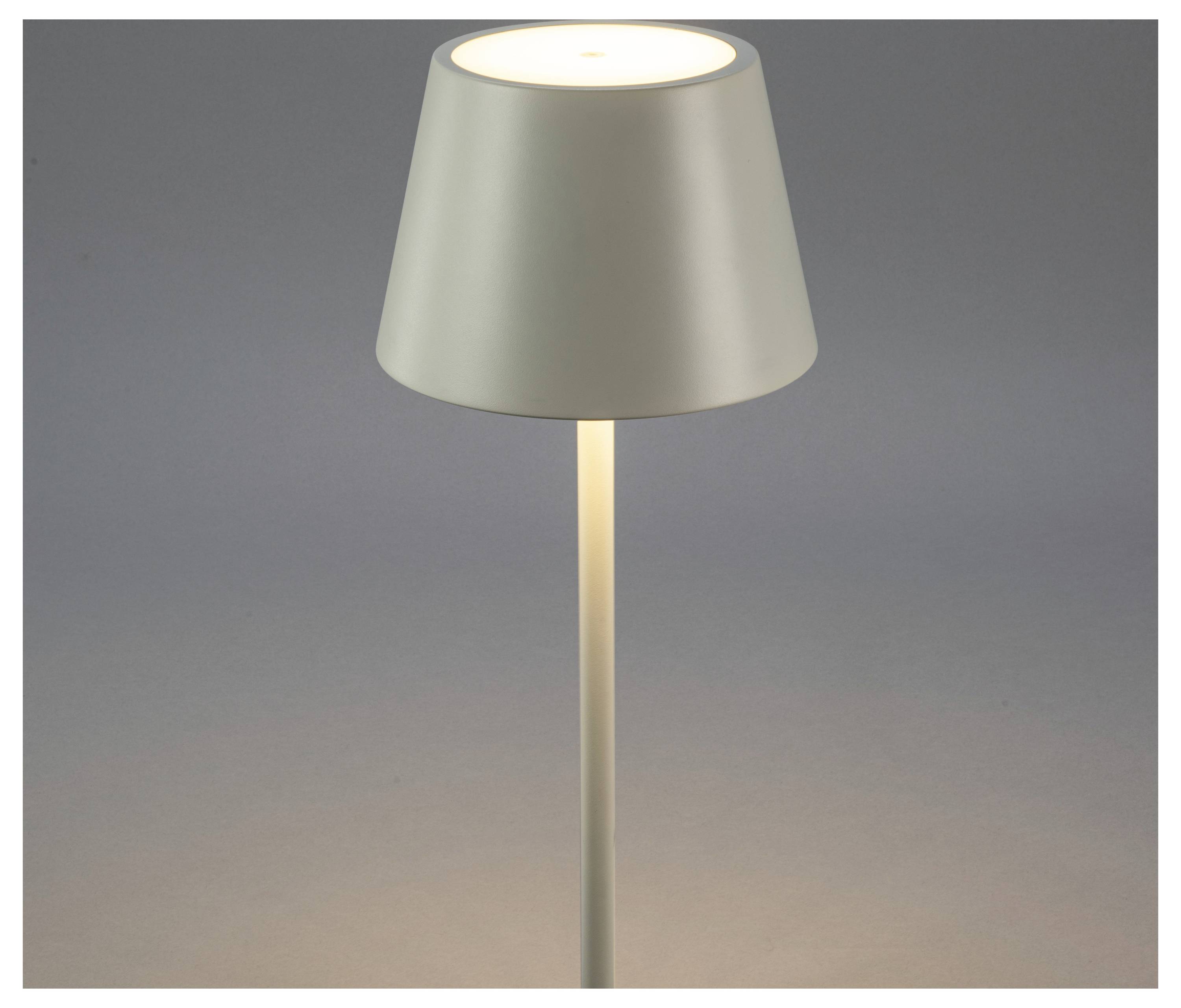 Jednoduchá, moderná stolná lampa s kónickým bielym tienidlom umiestnená na sivom pozadí, vyžarujúca jemné, teplé svetlo.