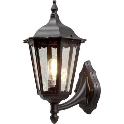 Čierna vonkajšia nástenná lampa v vintage štýle so sklenenými priehľadnými panelmi, pripevnená k stene domu, svieti teplým svetlom žiarovky vo vnútri.
