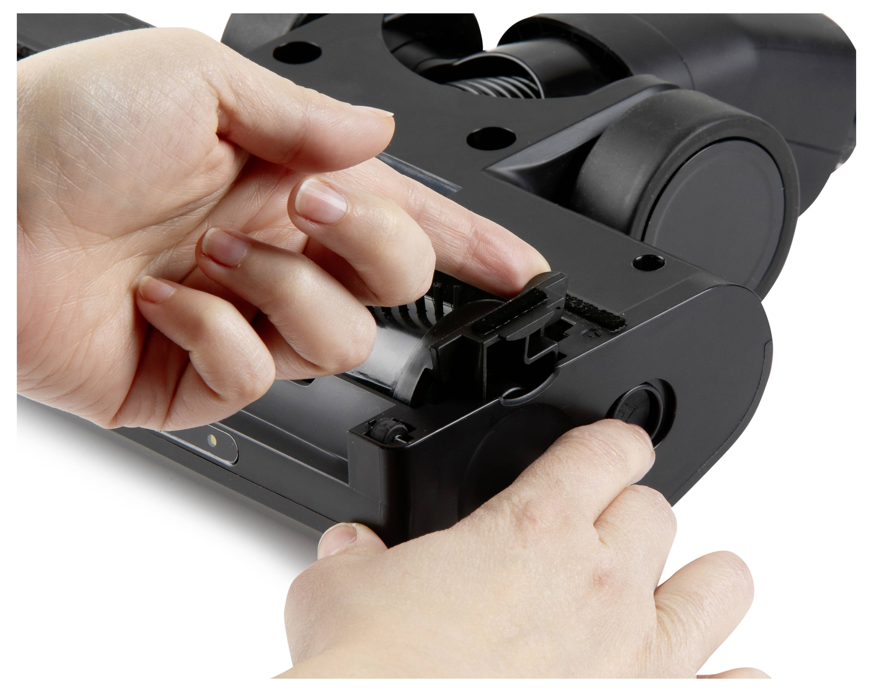 Osoba ukazuje, ako otvoriť kefovú hlavu vysávača pomocou dvoch rúk, pričom poukazuje na prístup k údržbe alebo čisteniu.