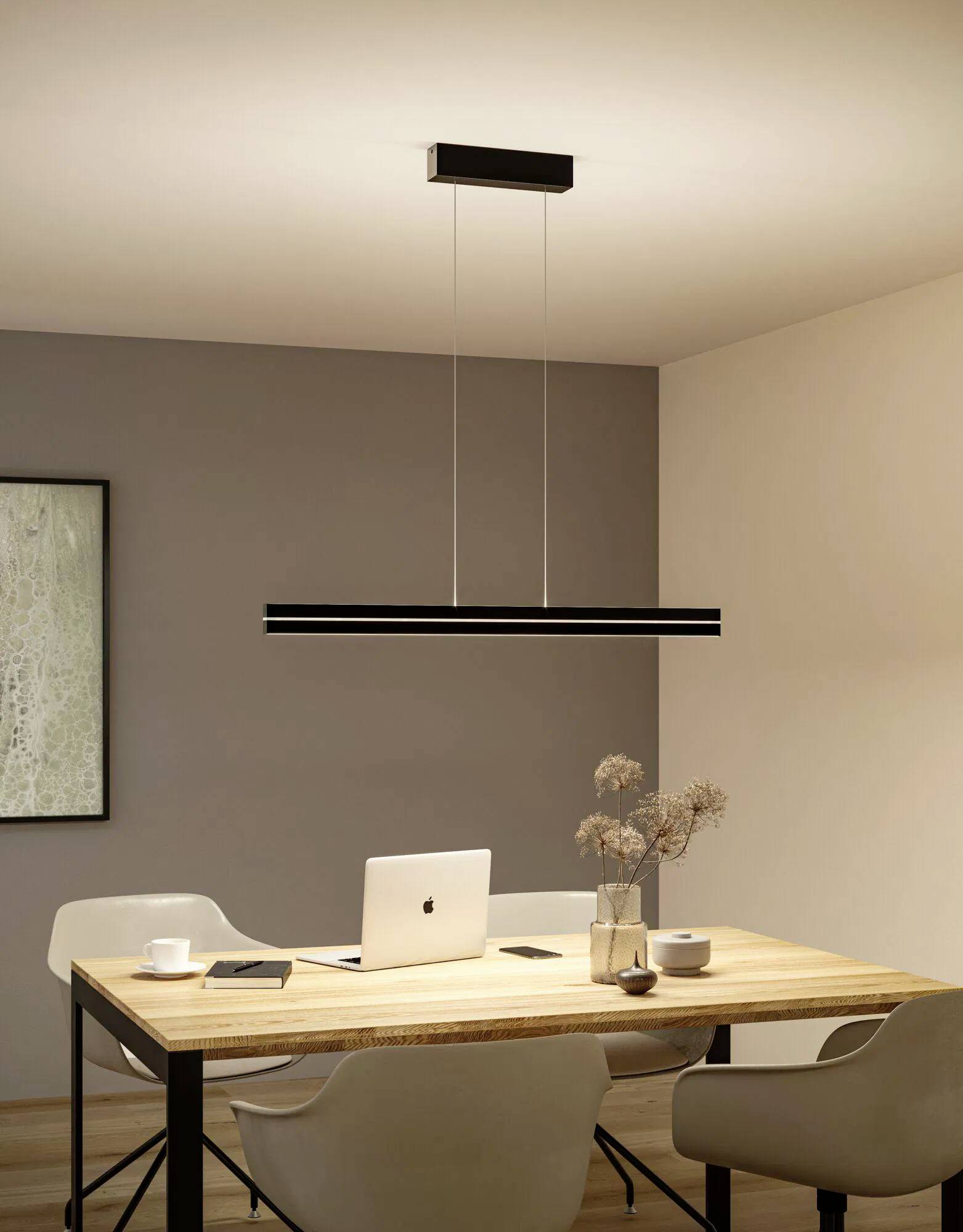 Moderná jedáleň s dreveným stolom, laptopom, dvoma bielymi stoličkami a štýlovým čiernym závesným svietidlom zavesenom nad nimi.