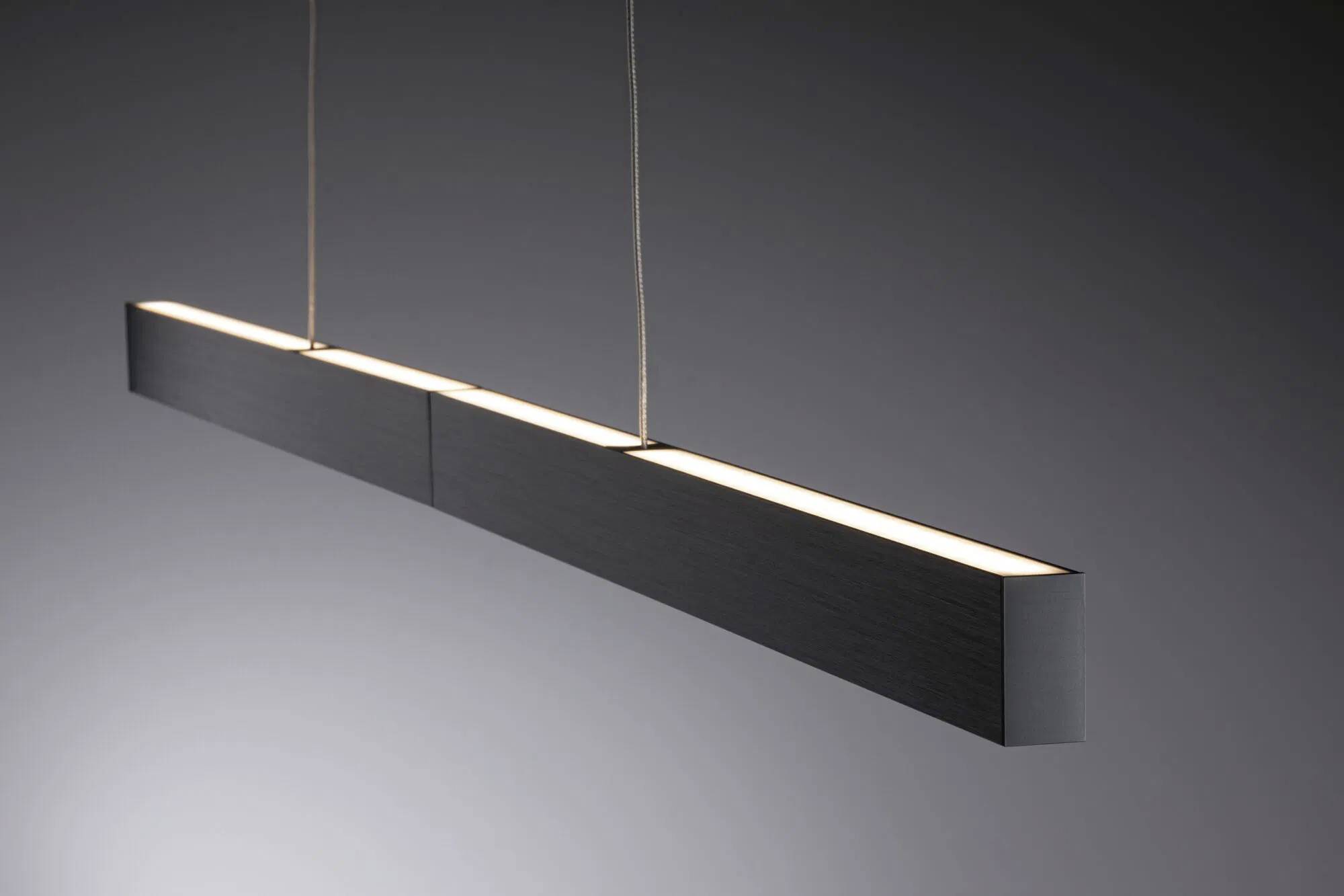 Elegantná, moderná závesná svetelná lampa, obdĺžnikového tvaru so jemným svetlom na tmavom pozadí.