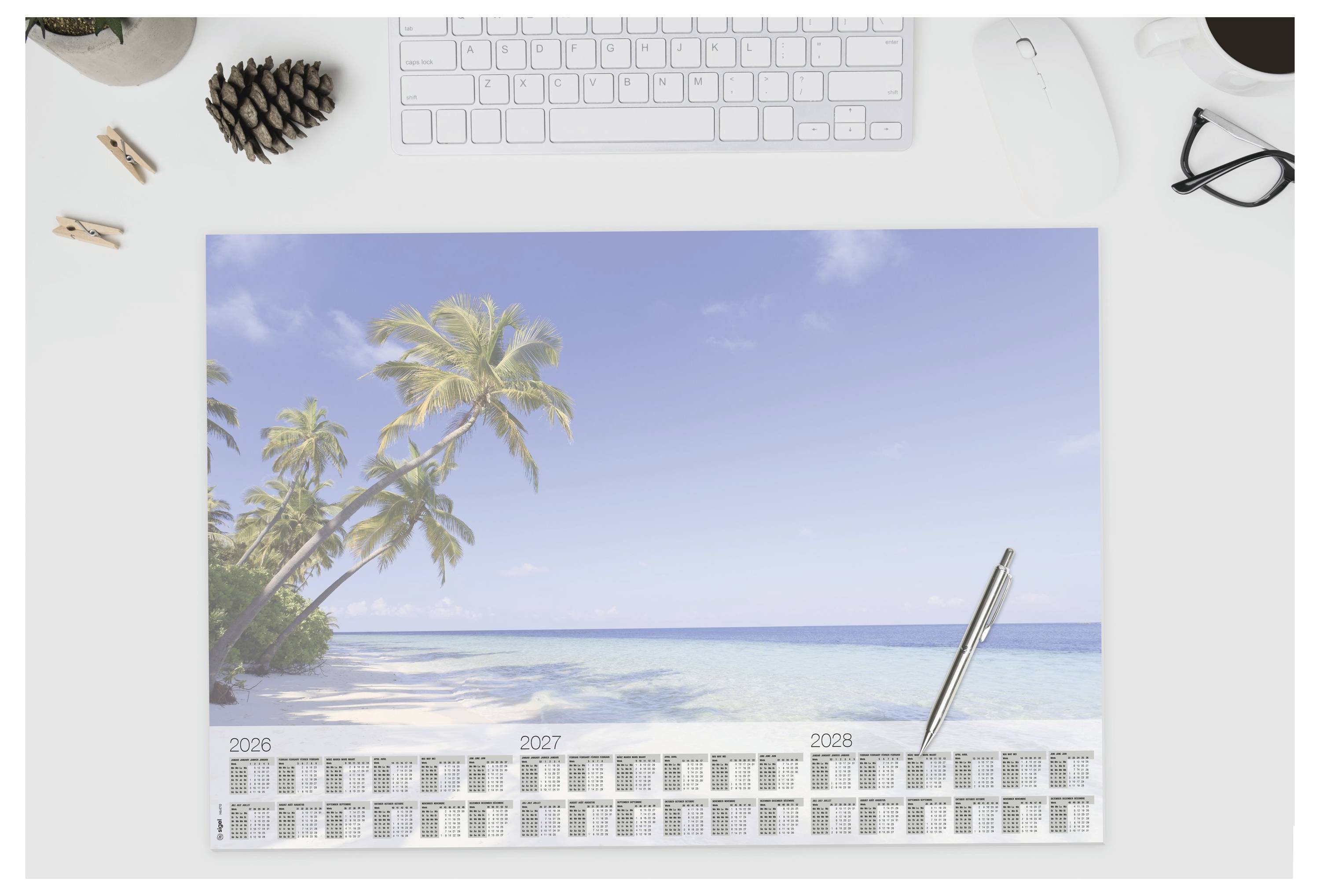 Stolový kalendár s výjavom tropickej pláže s palmami a modrým oceánom, zobrazujúci roky 2026, 2027 a 2028 v spodnej časti.