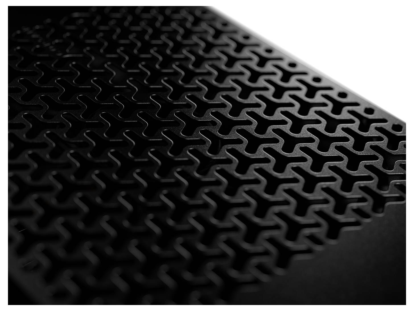 Detailný záber čierneho povrchu s geometrickým, navzájom prepojeným vzorom.