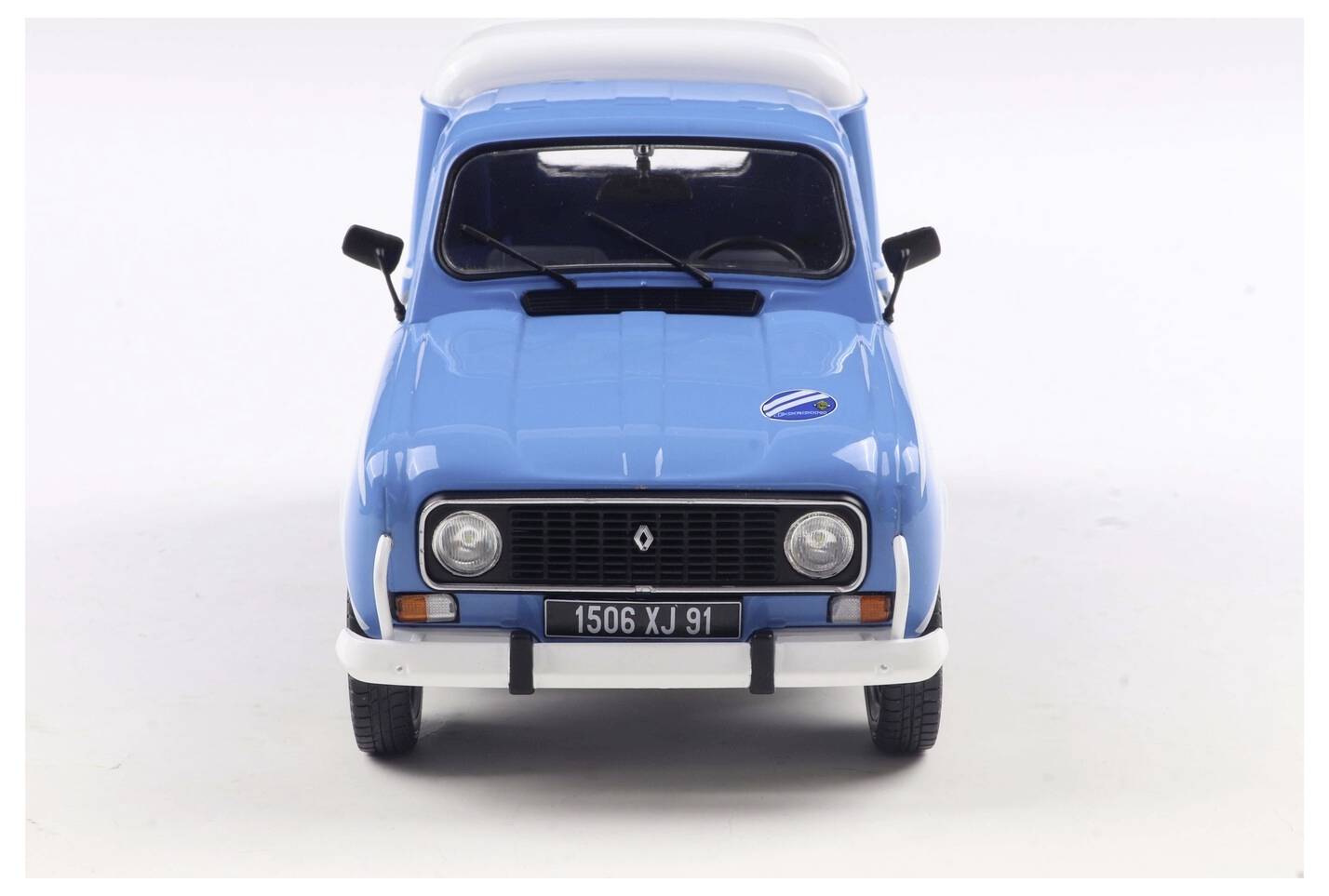 Spredu je zobrazené vintage modré auto s bielou strechou. Evidenčné číslo vozidla znie '1506 XJ 91'. Je to model klasického Renaultu.