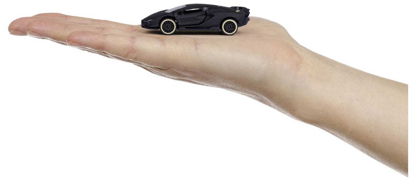 Čierne hračkárske auto je umiestnené na natiahnutej ľudskej ruke, čím sa ilustruje malá veľkosť auta v porovnaní s rukou.