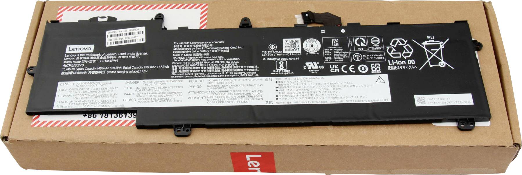 Obdĺžniková batéria Lenovo s viditelnými špecifikáciami a bezpečnostnými ikonami umiestnená nahnedej kartónovej škatuli s označením "Lenovo".